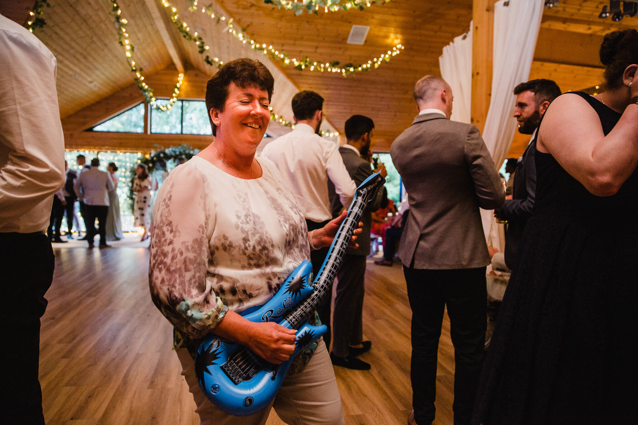 wedding guest with inflatable guitar on dance floor