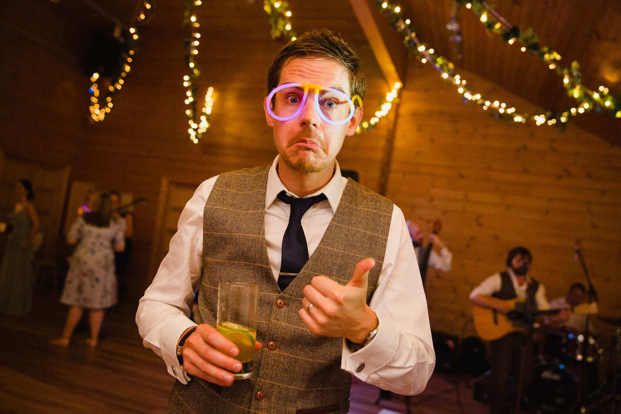 groom wearing neon glow glasses while looking at camera