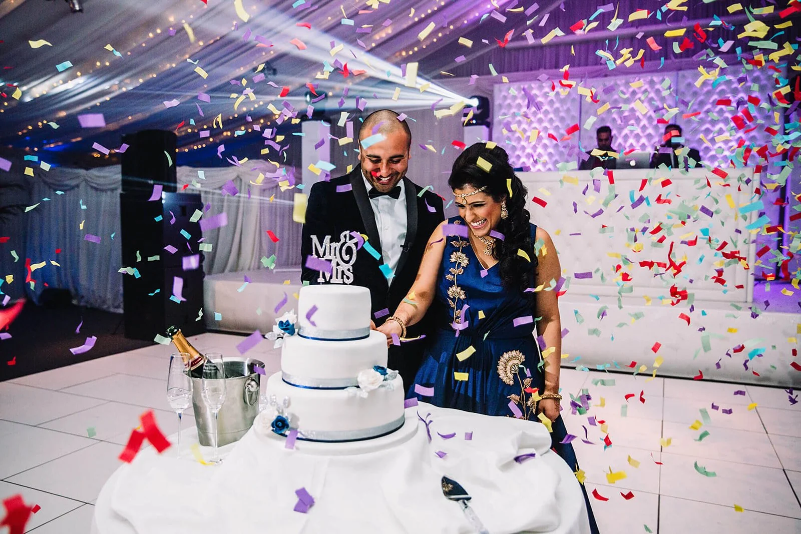 heaton-house-farm-indian-wedding-confetti-cake-cut.jpg  
