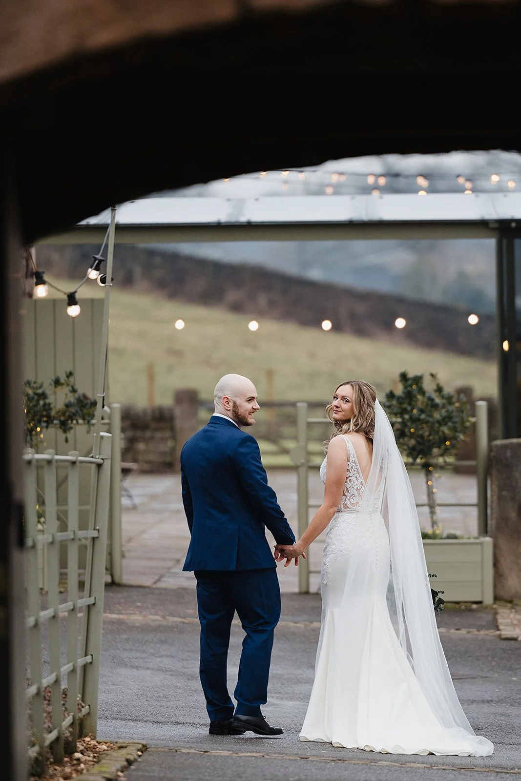 ashes-barns-wedding-stone-archway-bride-looking-back.jpg
