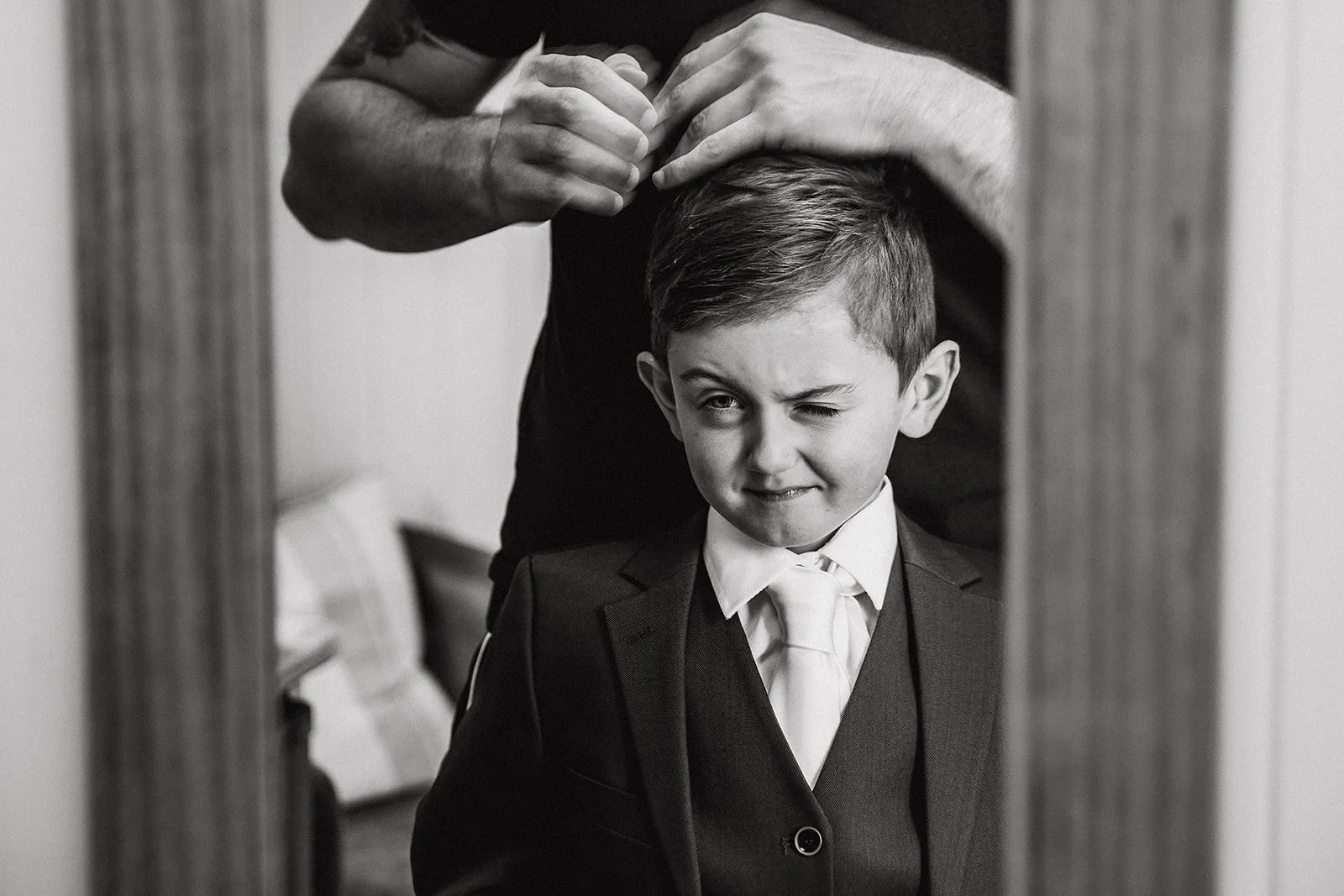 sandhole-oak-barn-wedding-groom-helping-young-pageboy.jpg