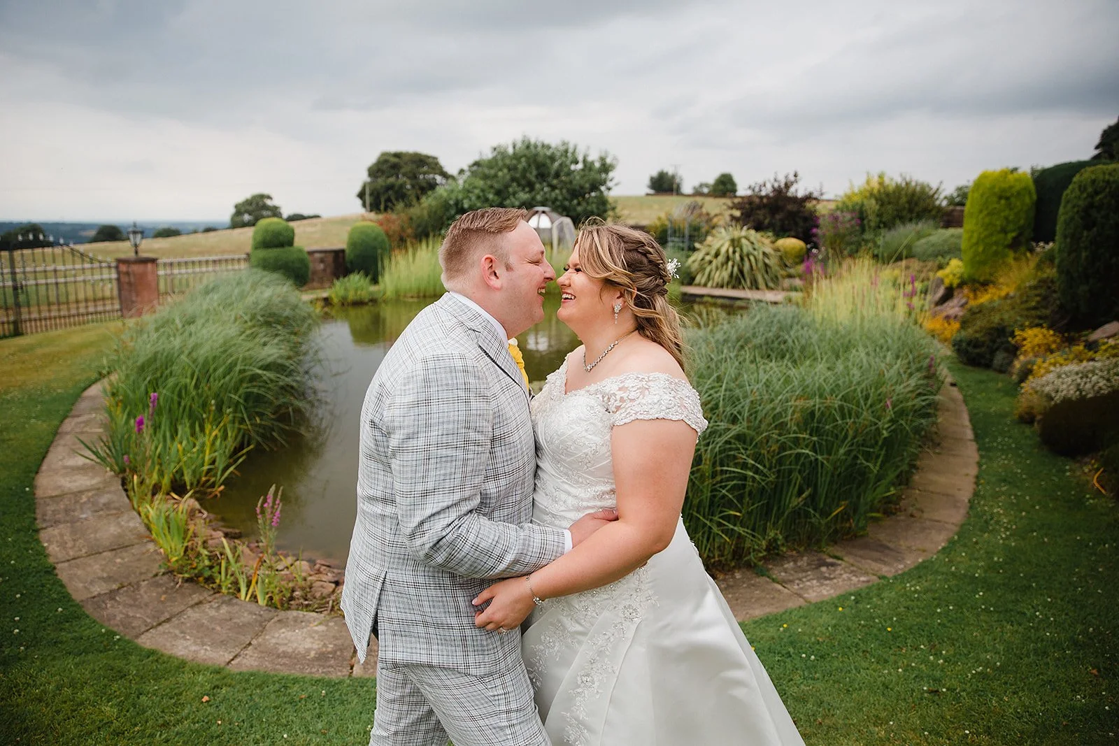 Bride and groom sharing a quiet moment by the pond during their intimate wedding at Heaton House Farm.