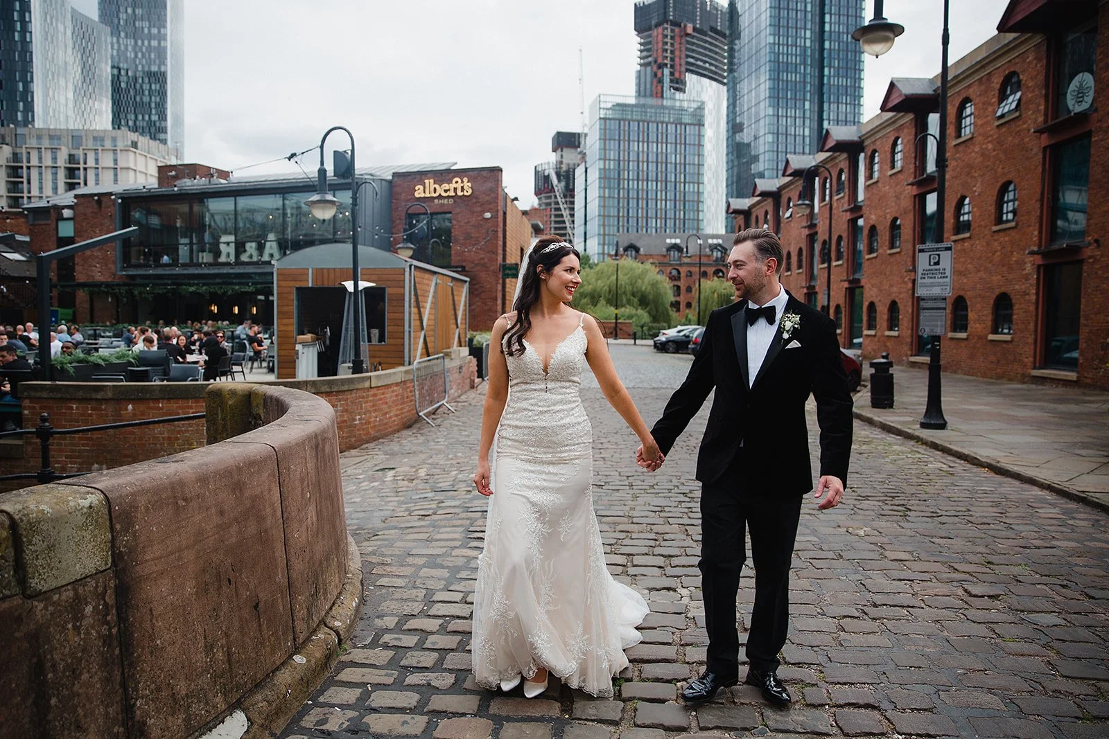 Bride and groom walking on cobbled street near Castlefield Rooms wedding venue Manchester