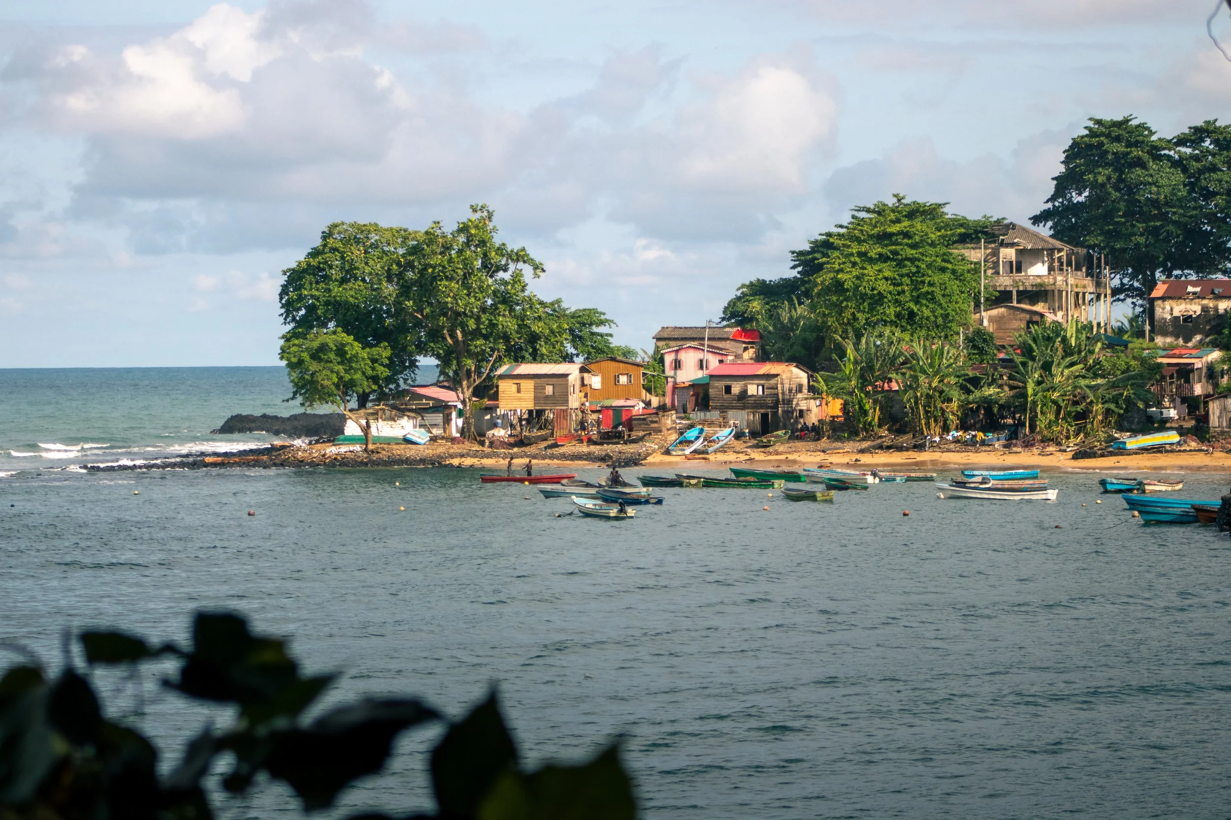 A tiny, colorful fishing village of Porto Alegre in São Tomé is basked in the golden hour sun