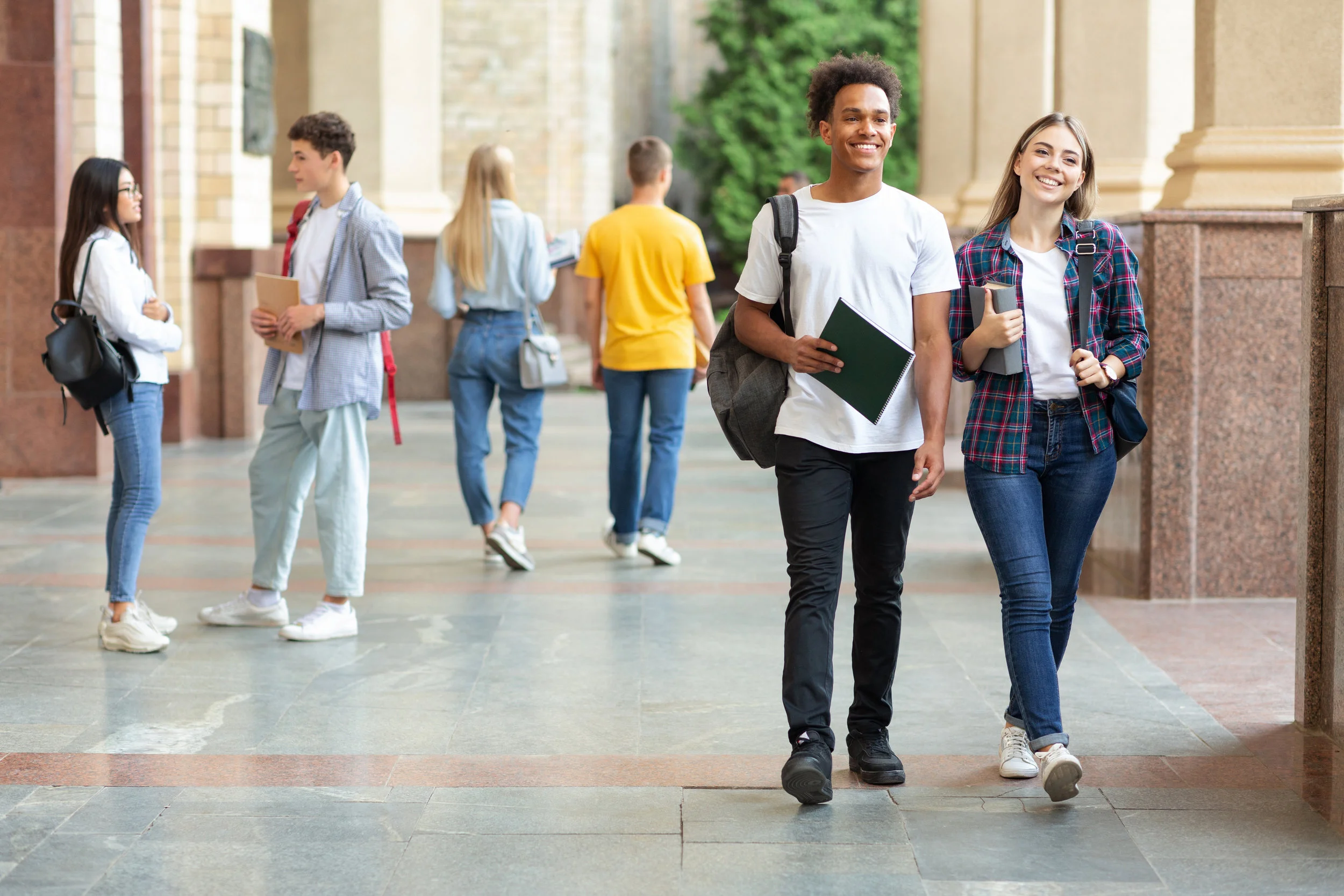 happy-college-classmates-walking-in-campus-during-YPMVDEN.jpg