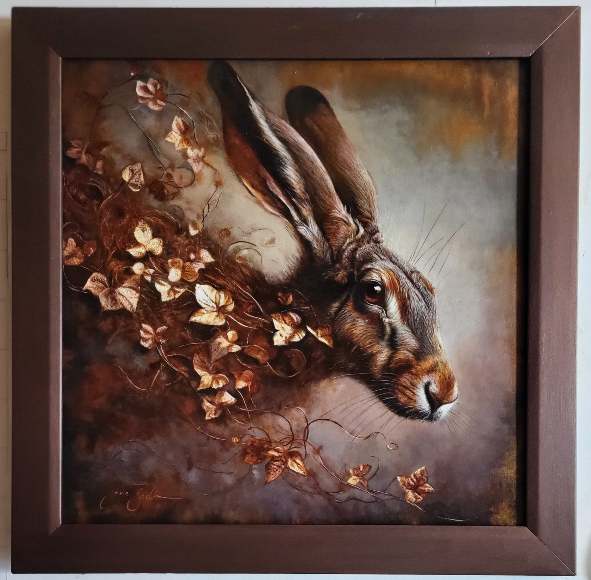 Framed painting of a hare lying on the ground surrounded by dried leaves and flowers.