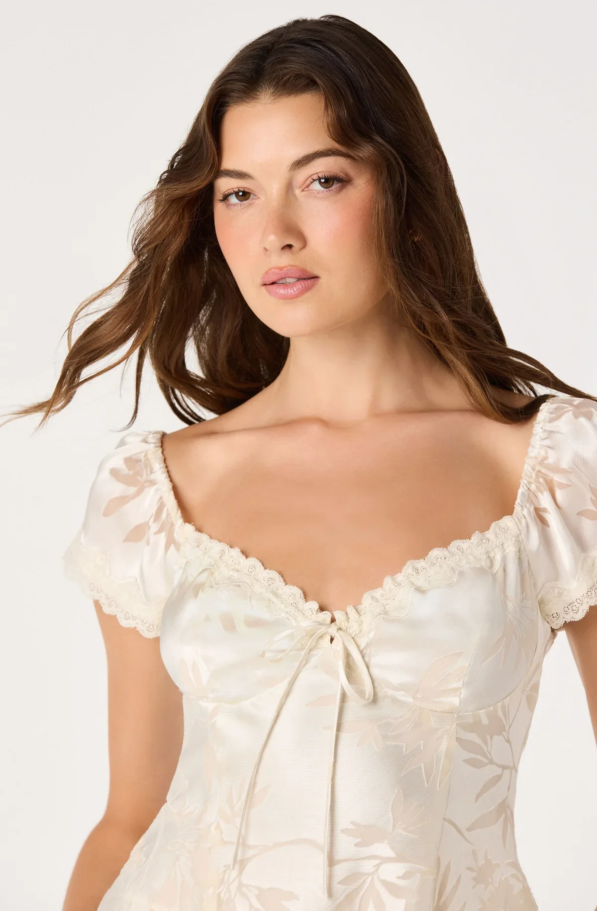 Close-up of the Vanessa cream top's front tie and puff sleeves