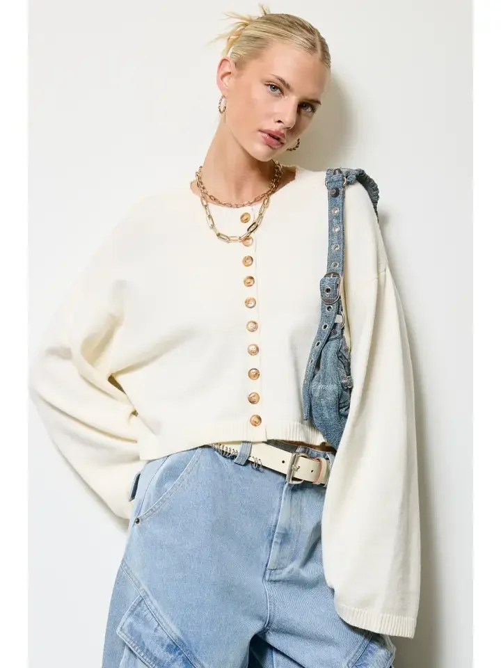 Button front cropped cardigan in bone with a denim bag