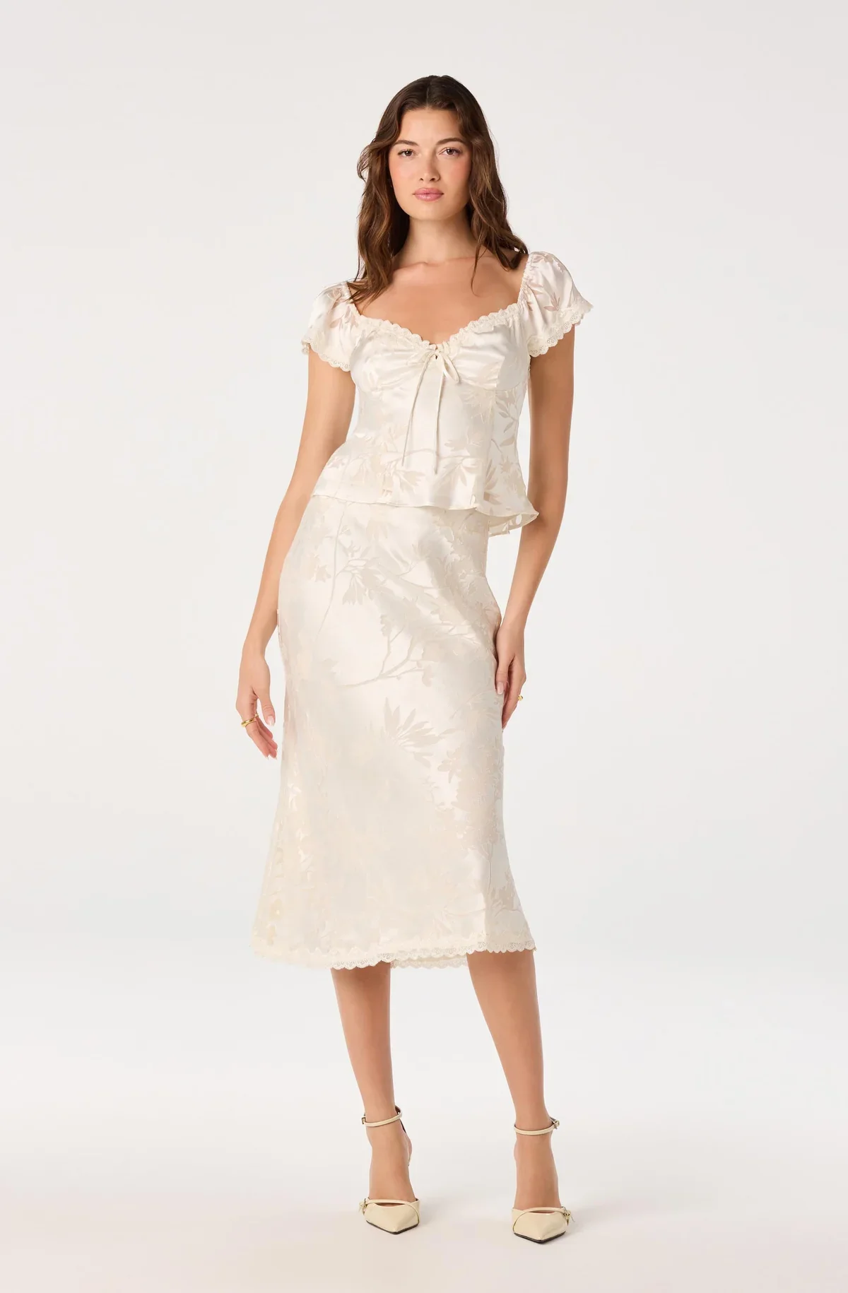 Full-length view of the Vanessa cream cap sleeve top with matching skirt and heels