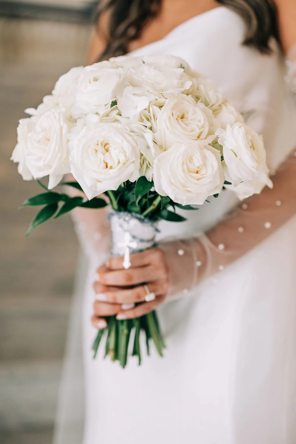 Bride holding a bouquet of white roses