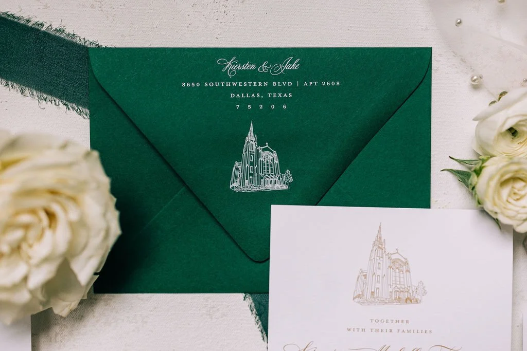 Green envelope with elegant white text and illustration of a church, alongside a white invitation card with a matching church illustration, decorated with white roses.