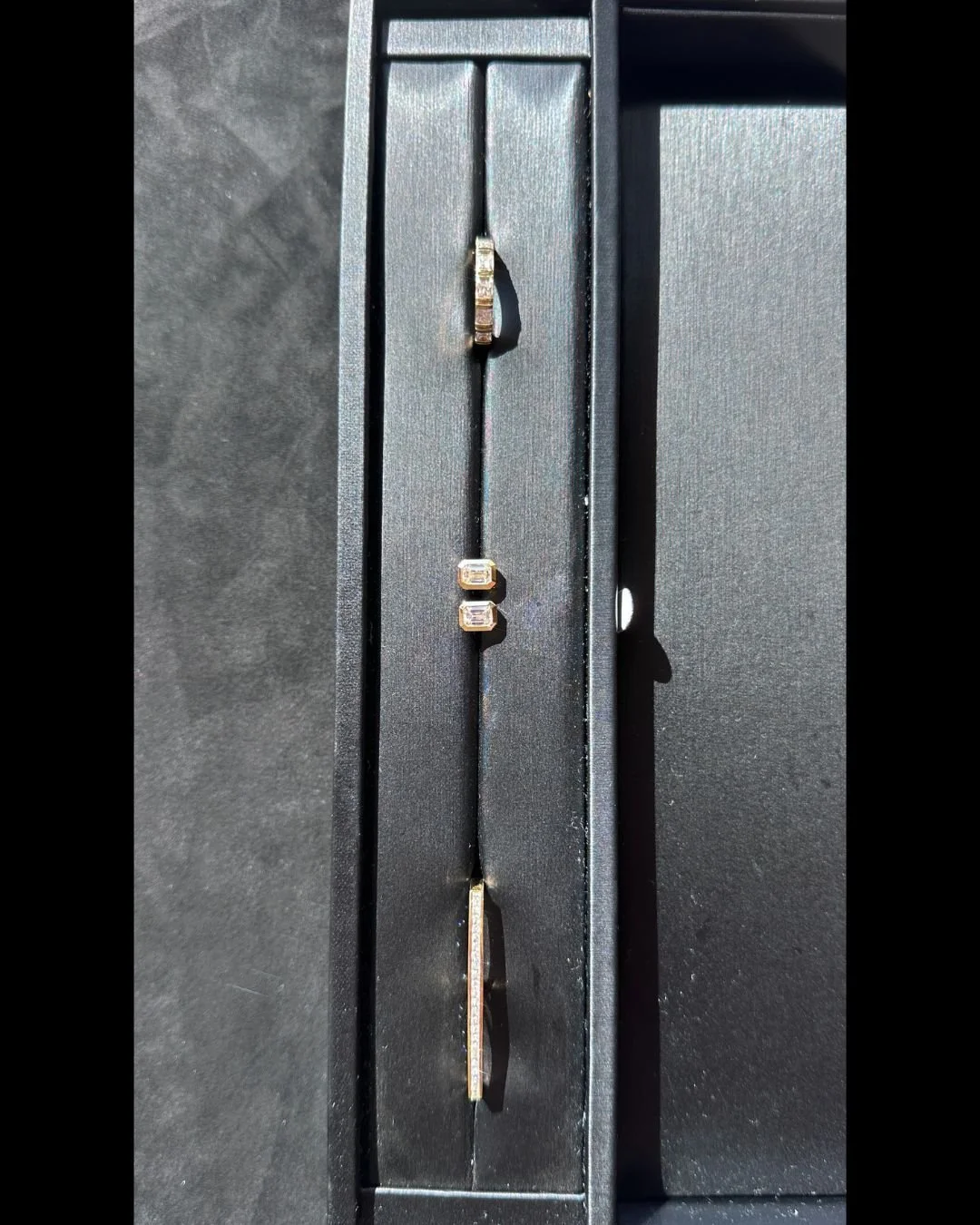 A quiet study in symmetry and structure.
Three pieces, one language &mdash; clean lines in gold. Preorder only. #TheSocietyHK #18KYellowGold #BezelSetting #PrincessCutDiamond #BaguetteDiamond #DiamondJewellery #FineJewellery #QuietLuxury #ModernHeirl