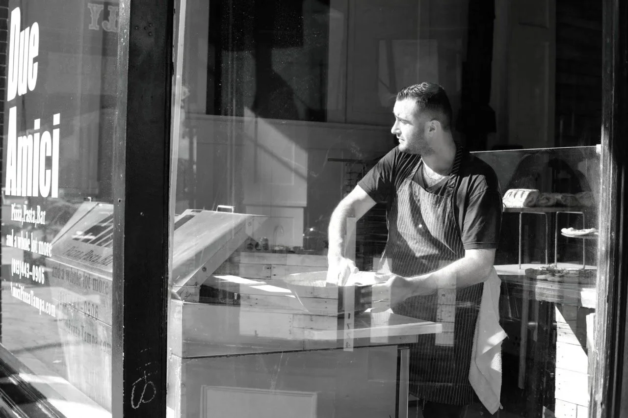 Black and white urban street photography scene with strong architectural contrast and shadow play