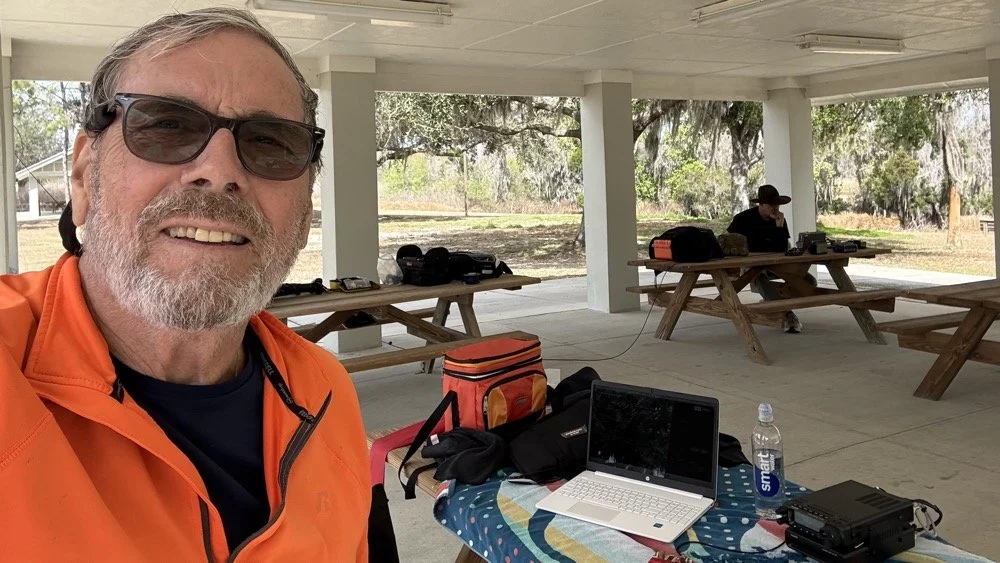 Chas NA2B operating a POTA activation at Alafia River State Park pavilion with WK4DS David in background multi-operator setup