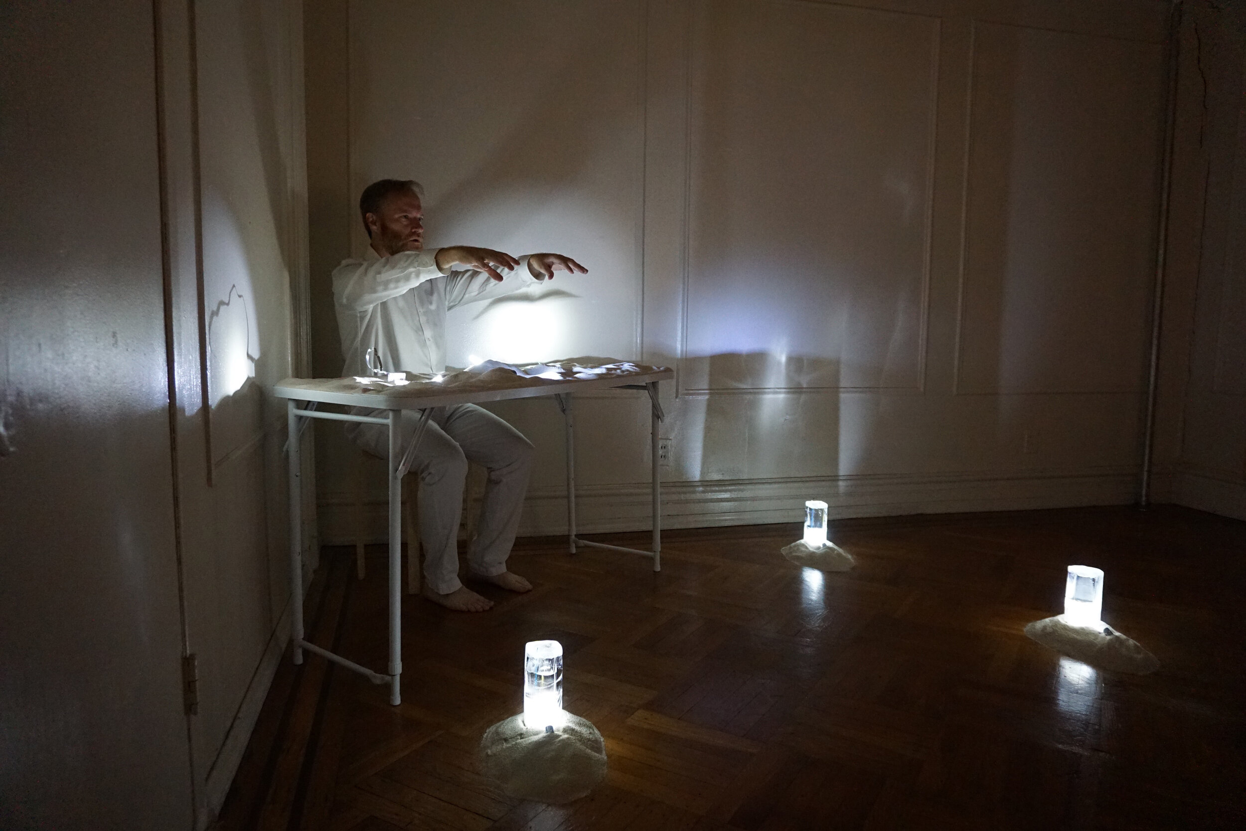 Calling You, live installation, duration: 1 hour, materials: ice, sand, flashlights, map, wire, the artist, and other found objects, 2020