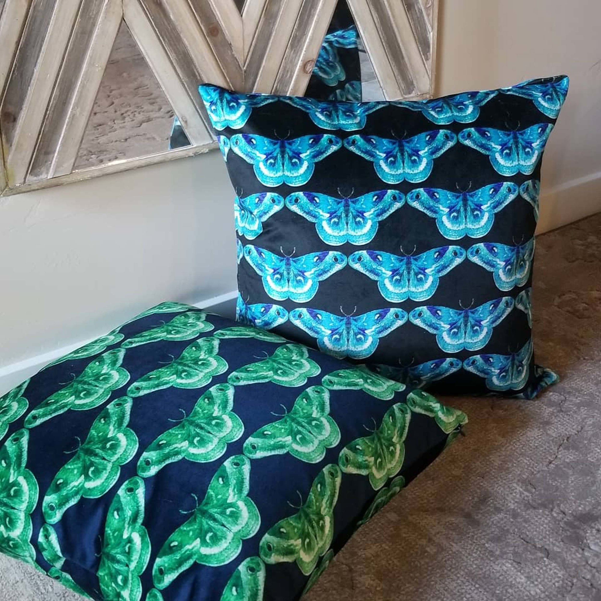 Set of black pillows with green and blue printed butterflies