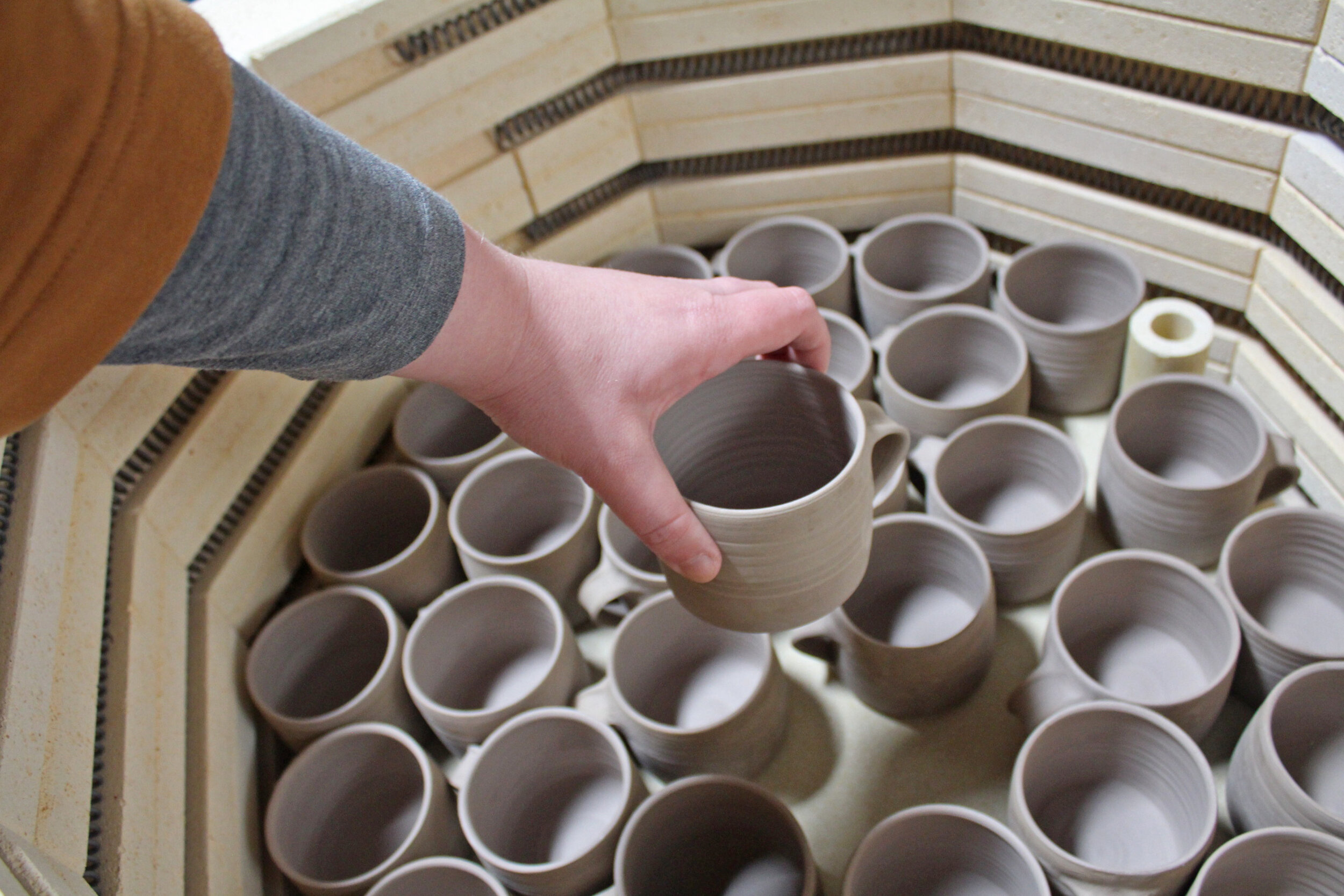 287 cups in kiln landscape hand.jpg