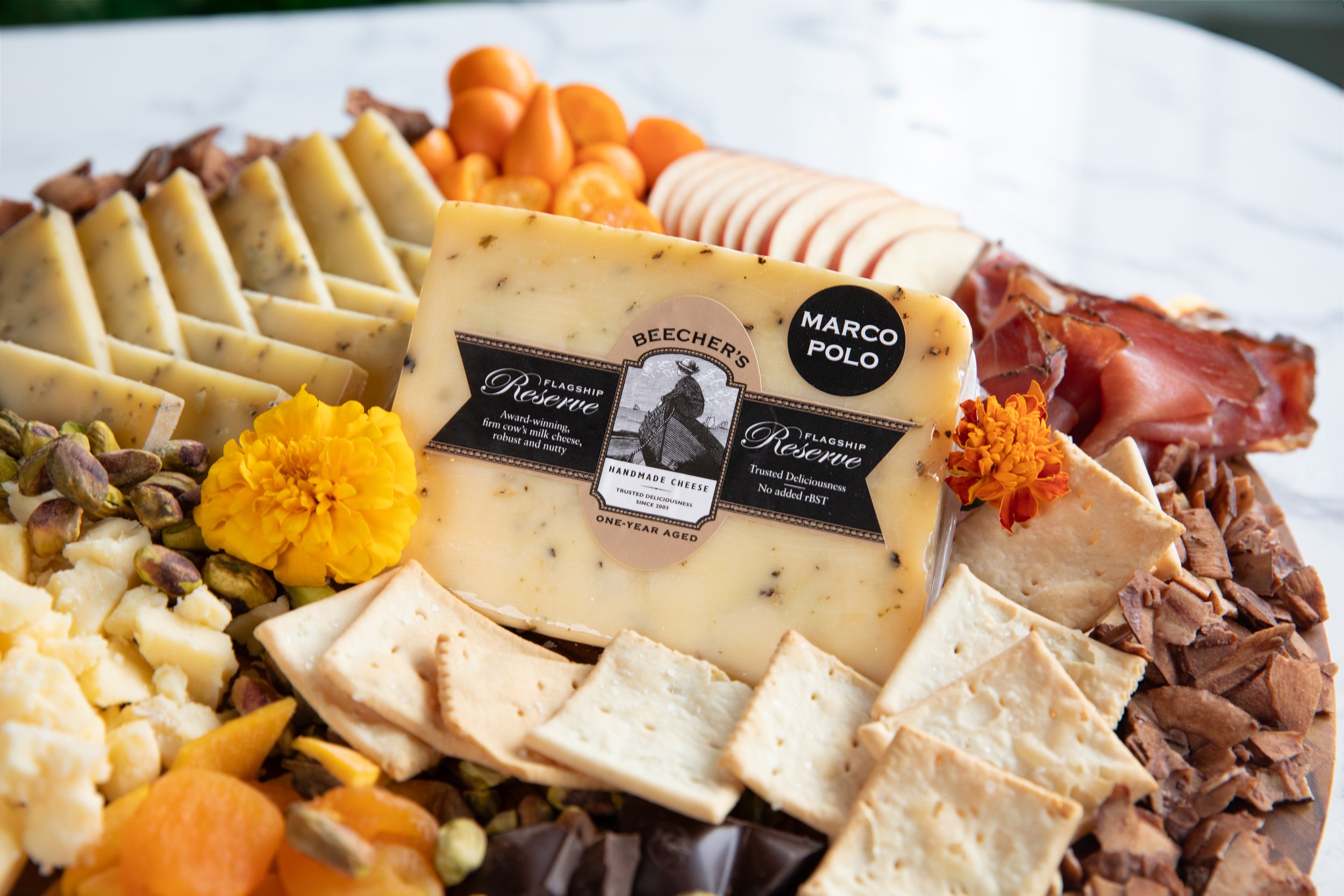 Cheese and charcuterie platter with various cheeses, meats, nuts, and garnishes.