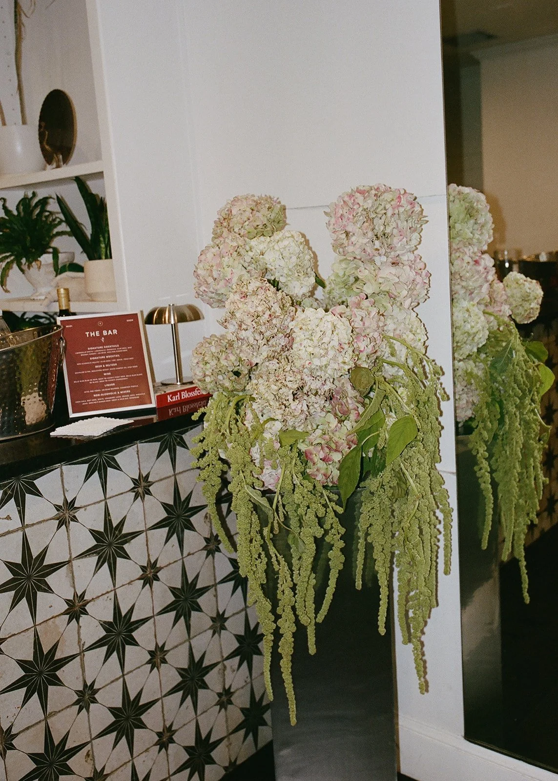 Large white and pink hydrangea floral arrangement with trailing green amaranthus at La Villa wedding venue in Kansas City.