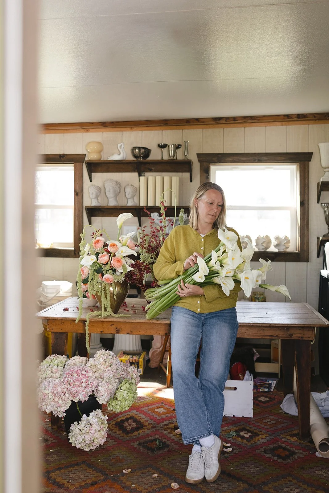 Saige of Elizabeth McKenzie Florals creating a wedding floral arrangement in her Kansas City home studio.