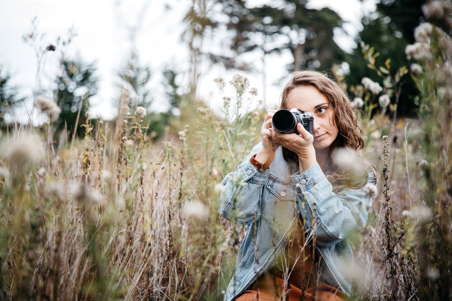  brand portrait of photographer Toni Toscano taking a photograph in a meadow of wildflowers at sunset, shot in the Presidio in San Francisco by brand photographer Allison Busch Photography 