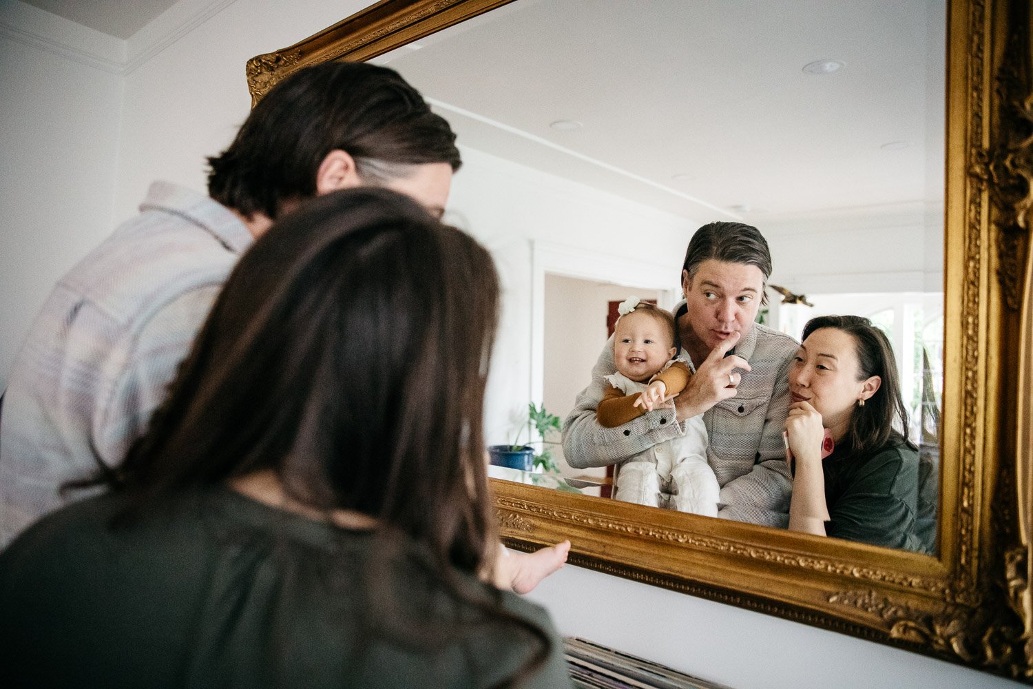  family photograph of mom, dad, and baby at home and making silly faces in a mirror, shot in Berkeley by family photographer Allison Busch Photography 