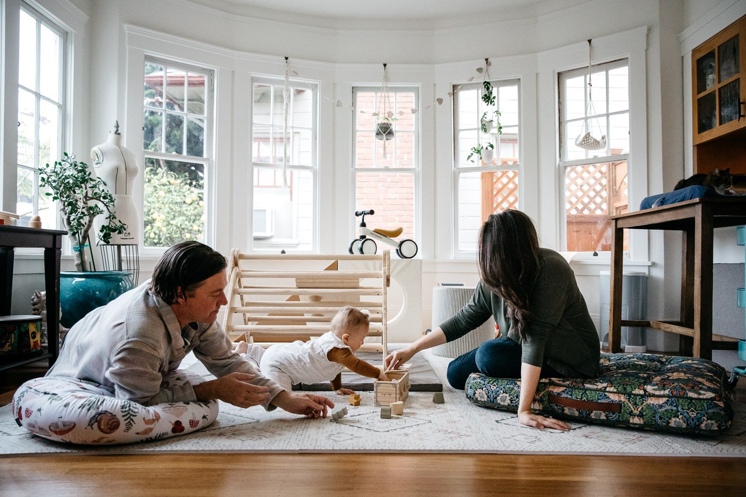  family photograph of mom, dad, and baby at home and playing on floor in light-filled room, shot in Berkeley by family photographer Allison Busch Photography 