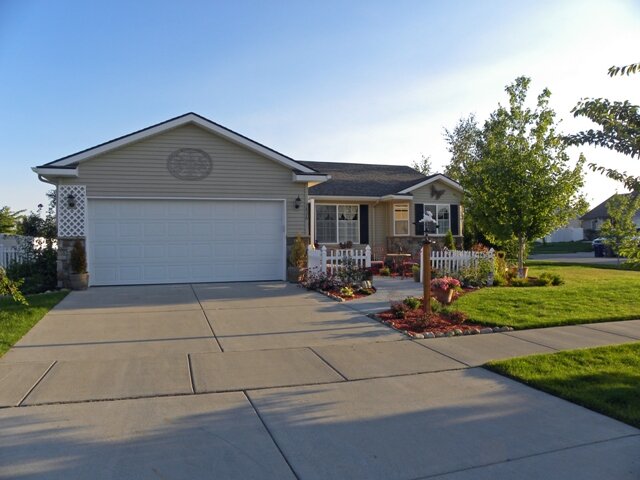  A newer tan home with a well-maintained, pretty yard. 