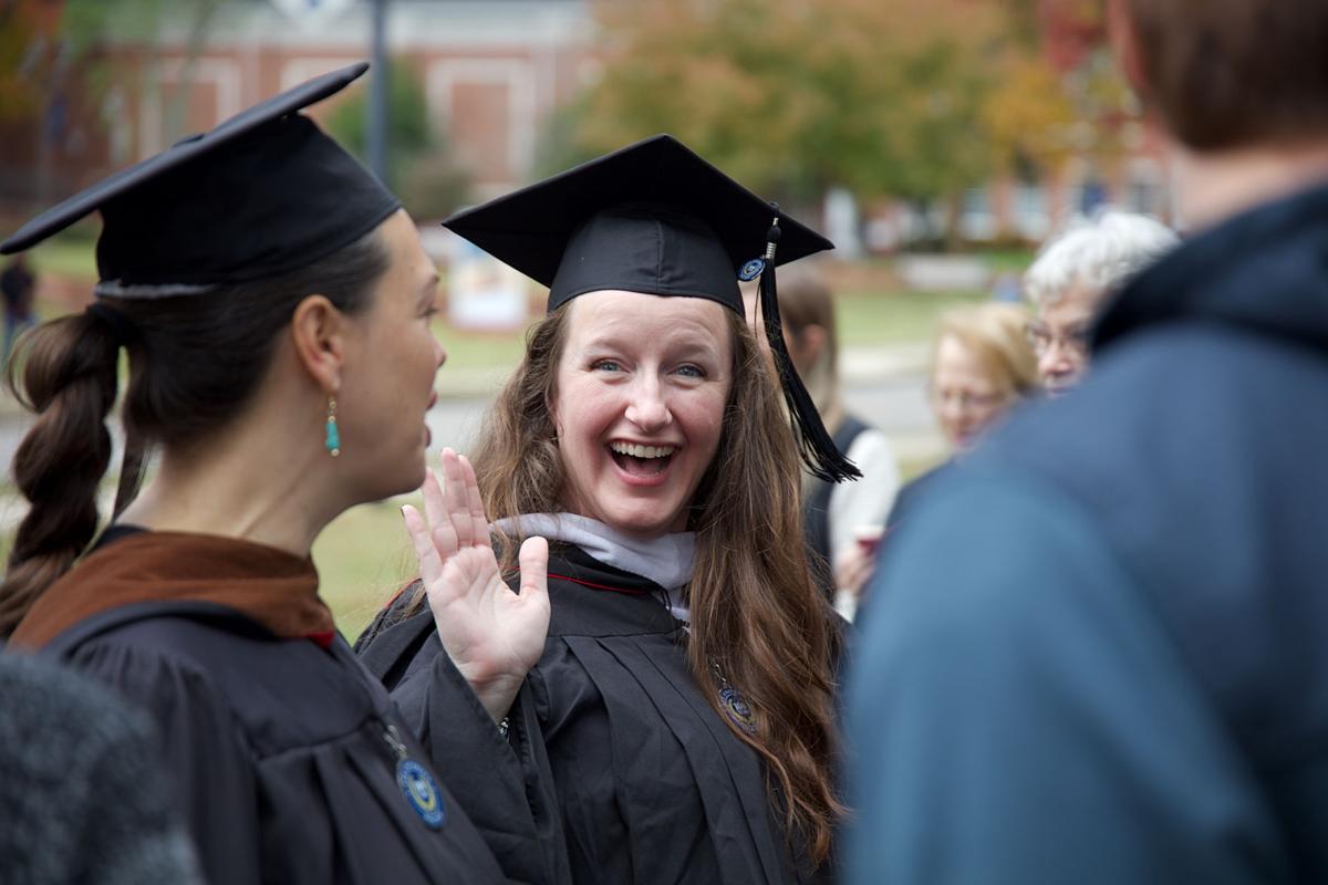 Visiting Lecturer Kimberly Lyon waves at students in the Walk of Gratitude during Homecoming.