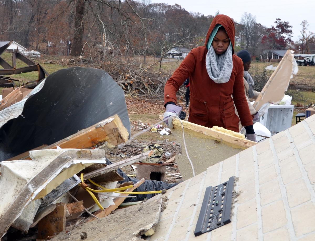 Tamerra Fleming moves debris from a pile on a site of tornado devastation in Polk County, TN on Saturday, Dec. 3.