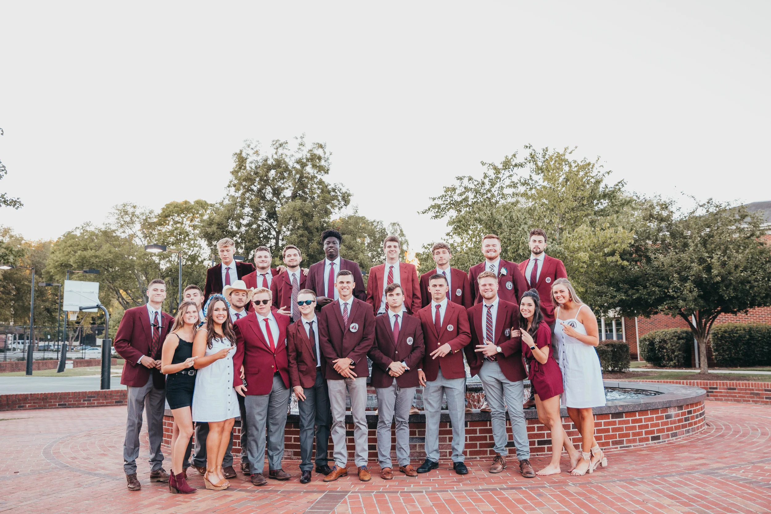 Alpha Gamma Chi members pose in front of the eternal flame for a group photo.