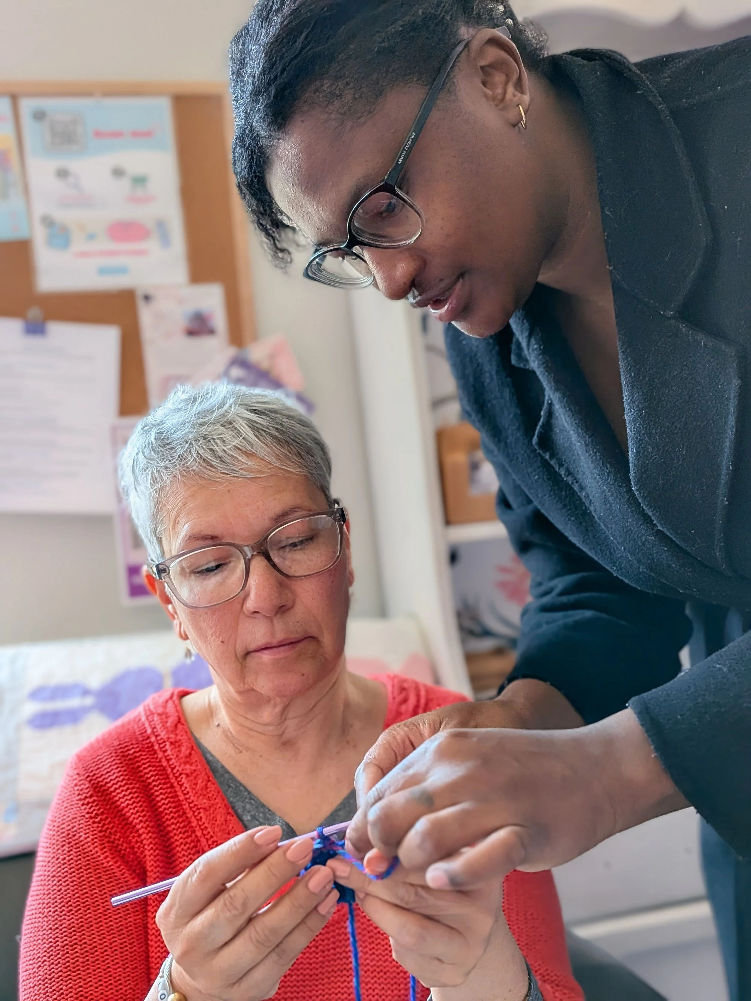 Volunteer teaching to crochet magic circle in hearts for miscarriage support packages