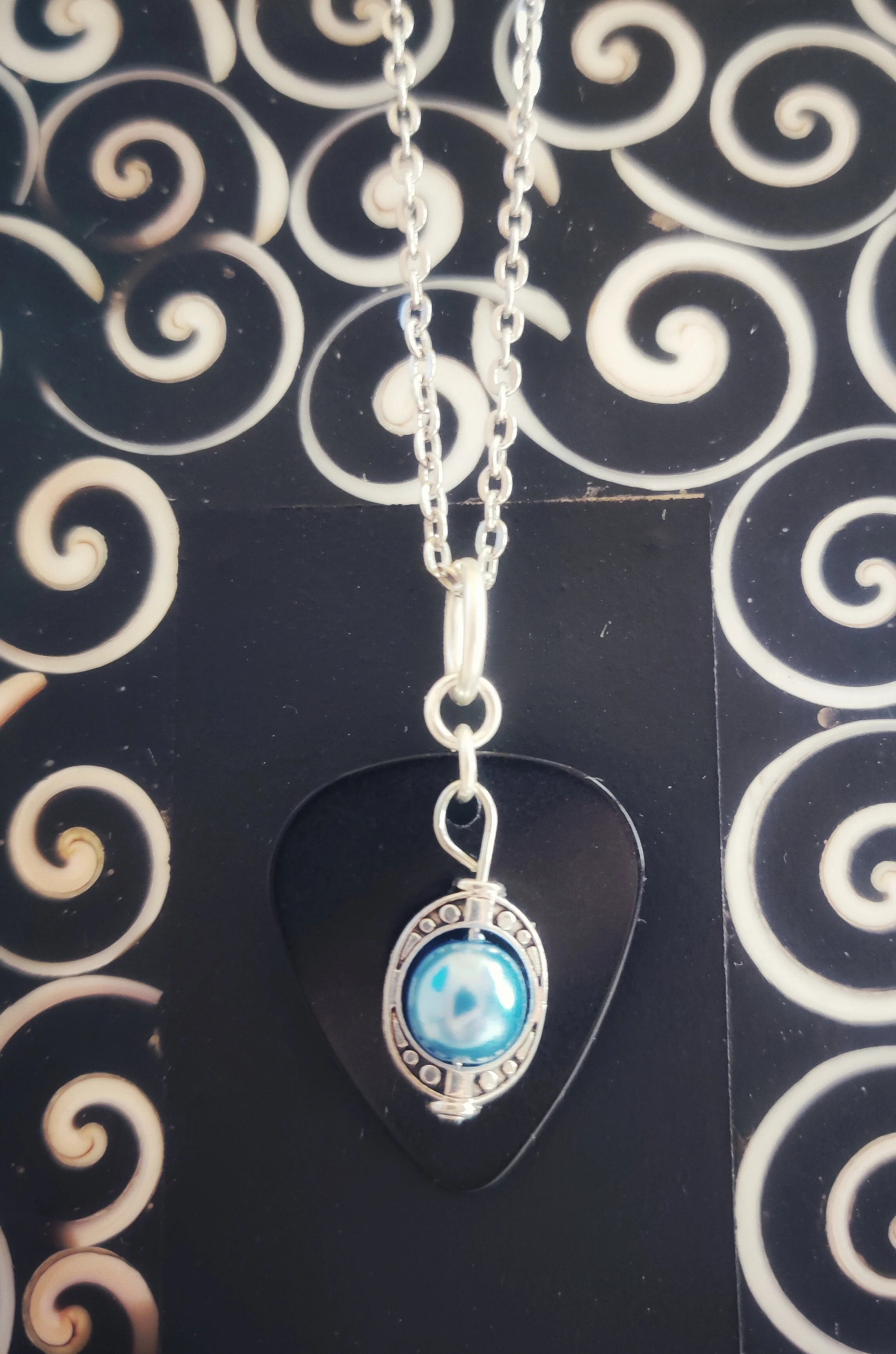 Guitar pick shaped pendant with a pearl