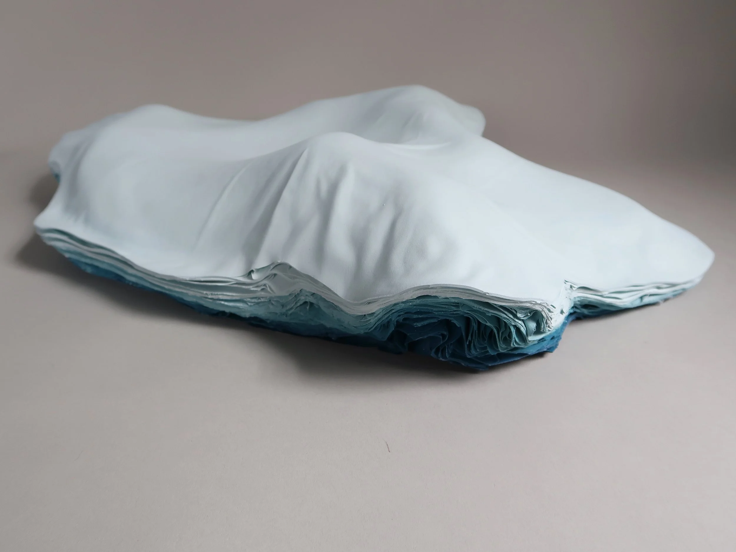    untitled (sastrugi IV)  , 2025, Recycled Film Projection Screen, Recycled Interior House Paint, Recycled Cardboard Shoe Inserts, 3.25 × 13.125 × 17.75” 