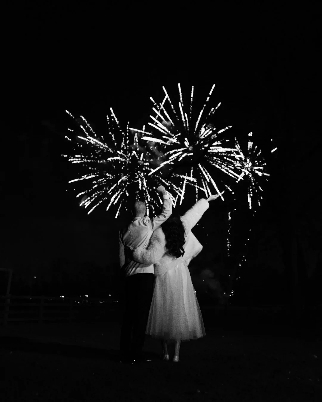 Couple celebrating New Year's or a special event with fireworks at night.