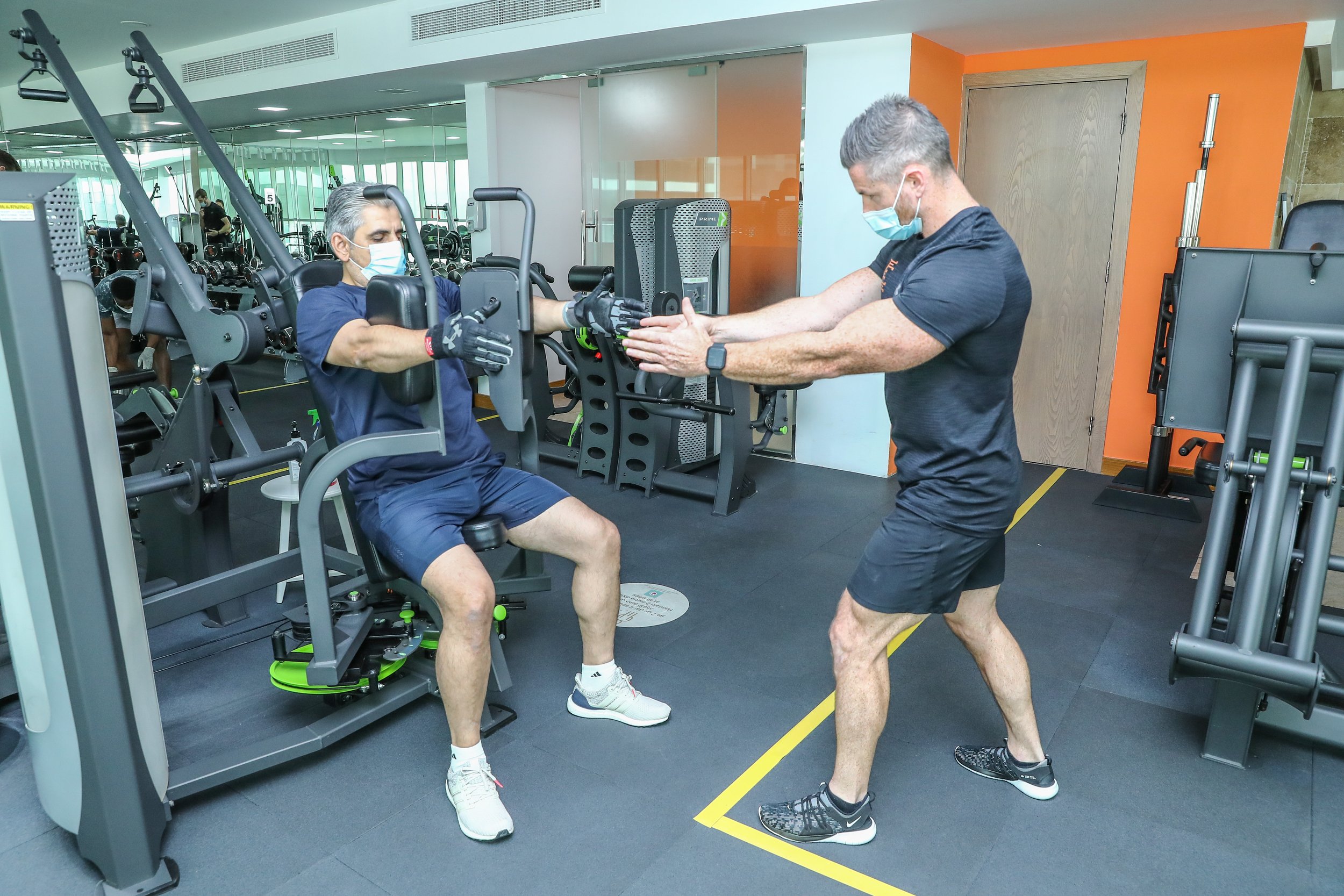 Ayman performing pec fly with coach james instructing image 2.jpg