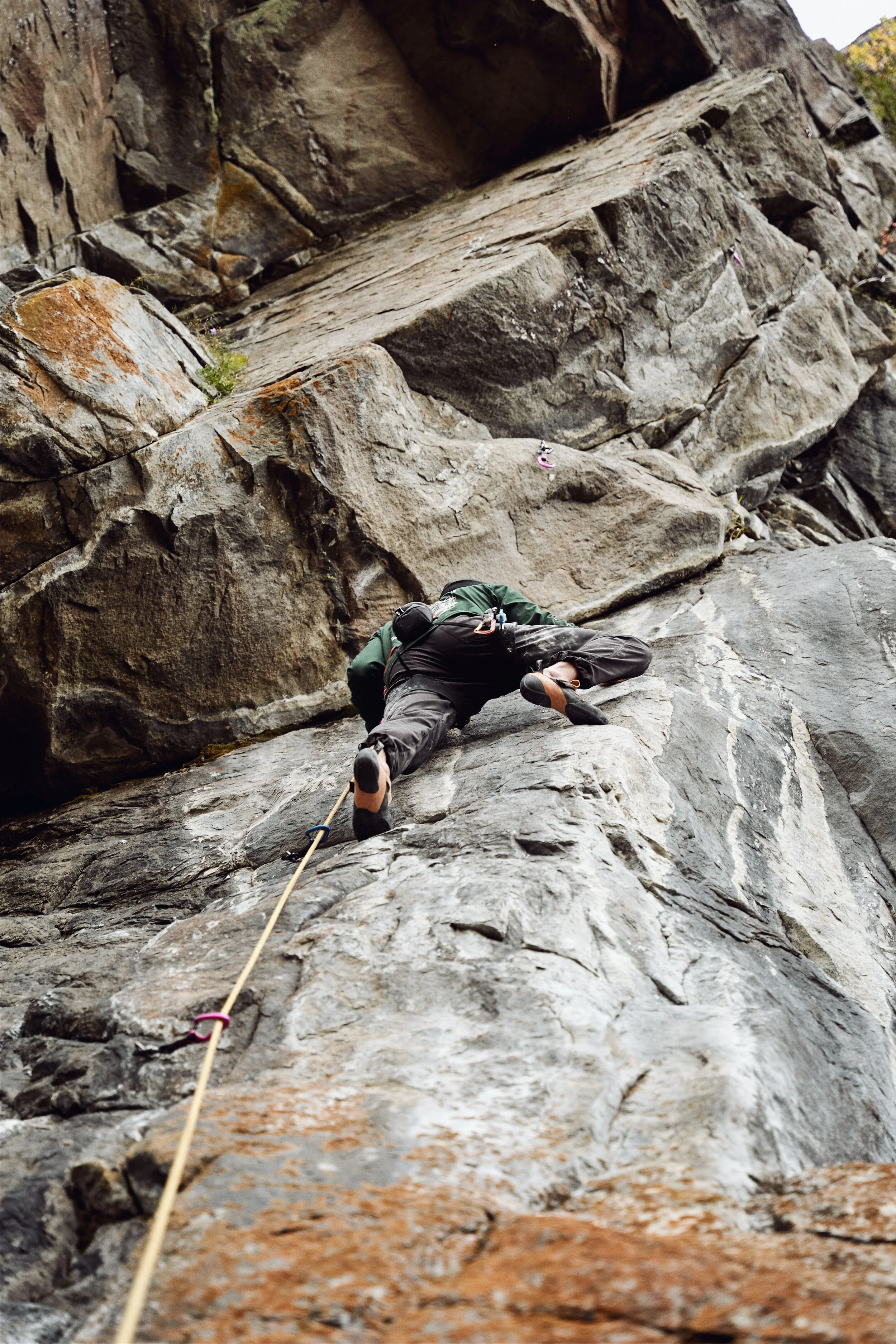 A person rock climbing on a steep, rugged rock face.