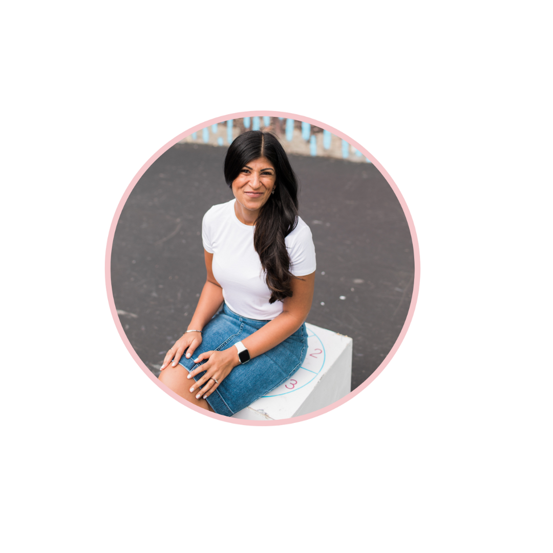 Saira Gangji of Hrology, white shirt, blue jeans, with white apple watch, sitting and smiling at the camera.