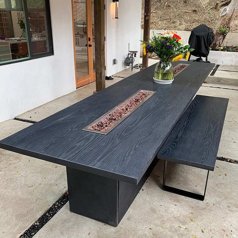 Custom dark wood table with matching benches on a covered patio