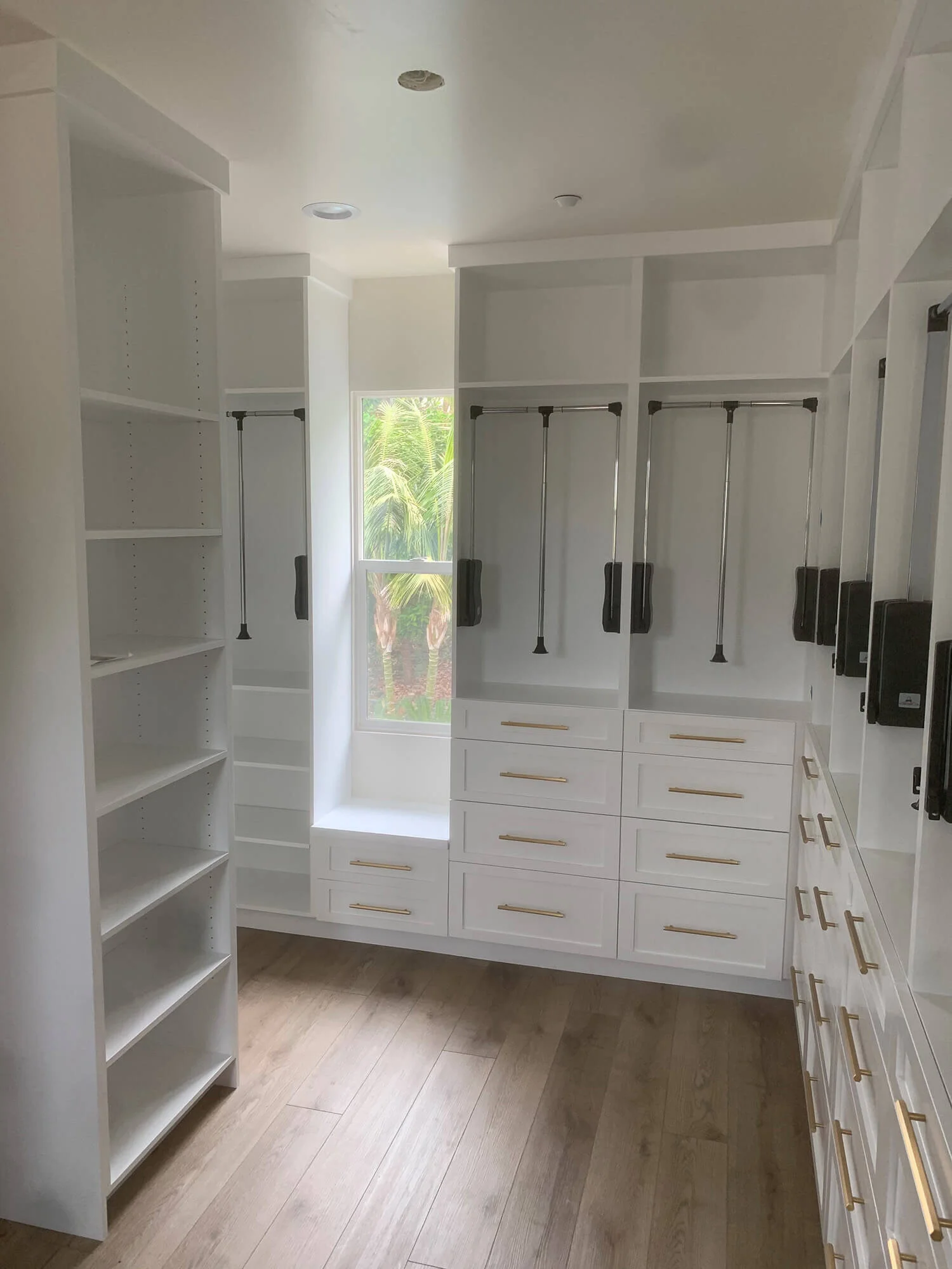 White walk-in closet with shelving, hanging rails and drawers