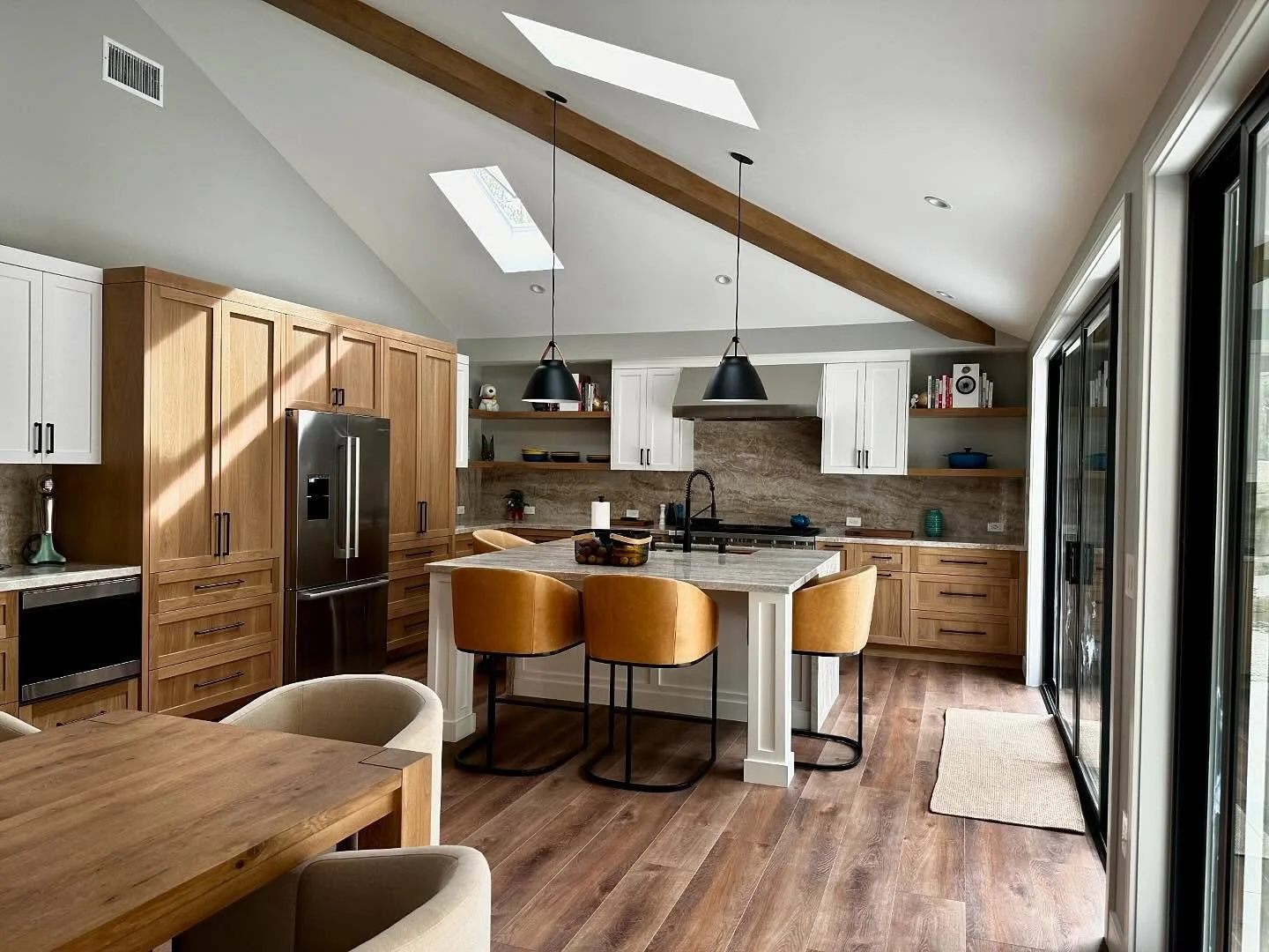 Wood kitchen cabinetry and island beneath timber beams
