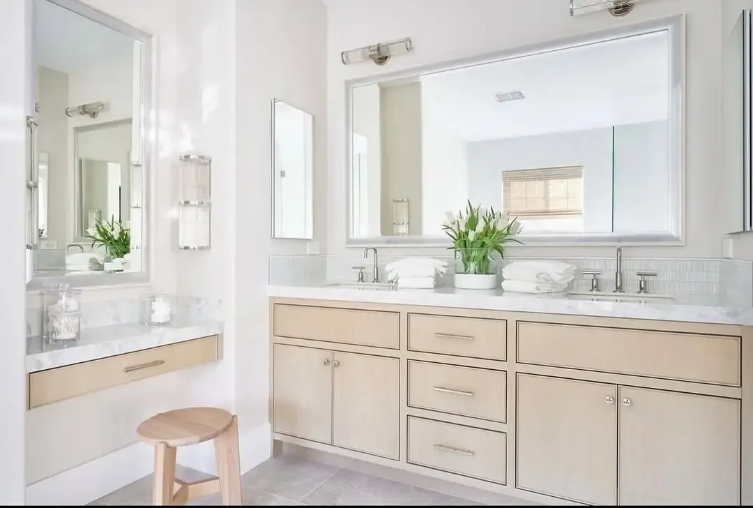 A tidy bathroom showcasing a stylish custom vanity with a mirror, emphasizing a modern and elegant design.