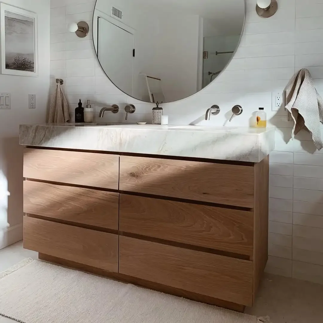 A standard-sized bathroom with a wooden vanity and mirror, emphasizing a simple and elegant design.
