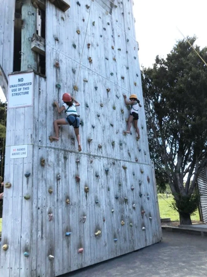 Persevering on the climbing wall at camp.