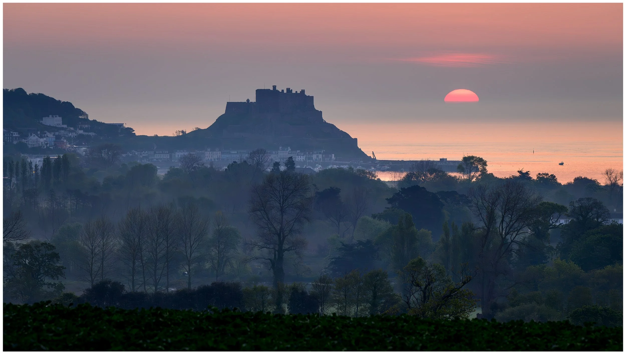 Sun braking the horizon behind Gorey Castle