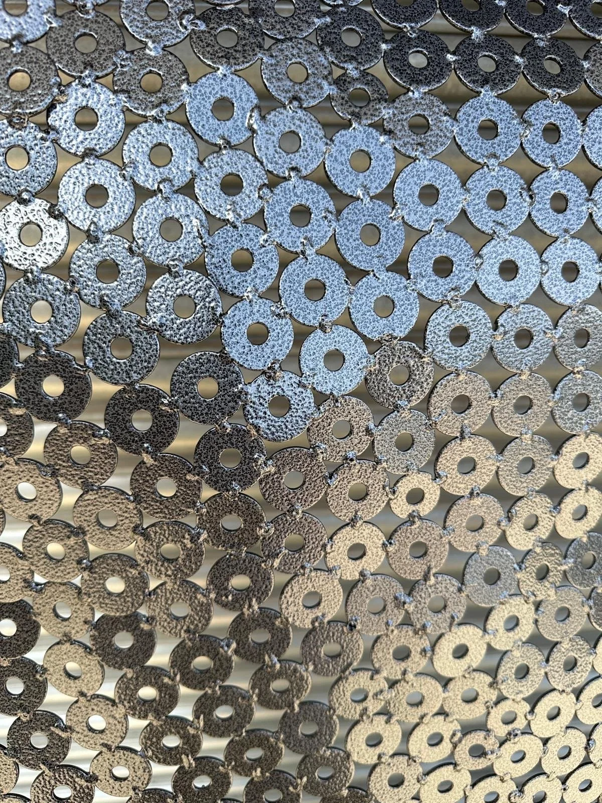 recycled metal washers used to create a large mask sculpture