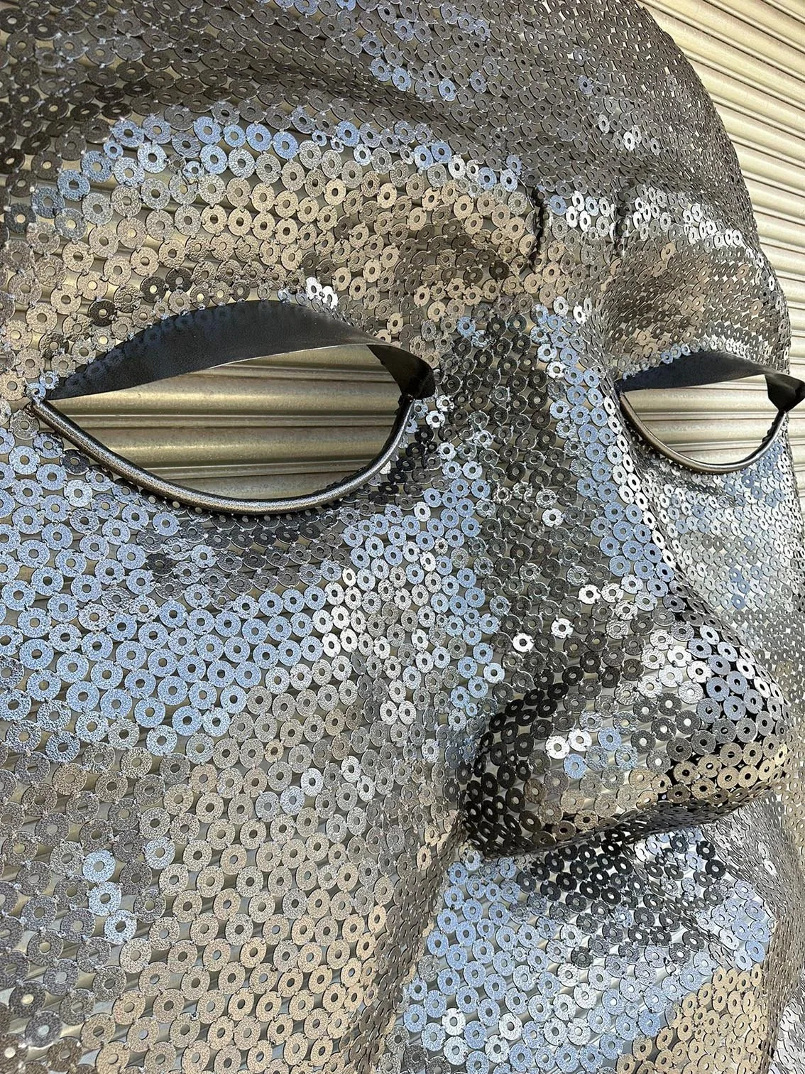 recycled metal washers used to create a large mask sculpture close up of eyelids