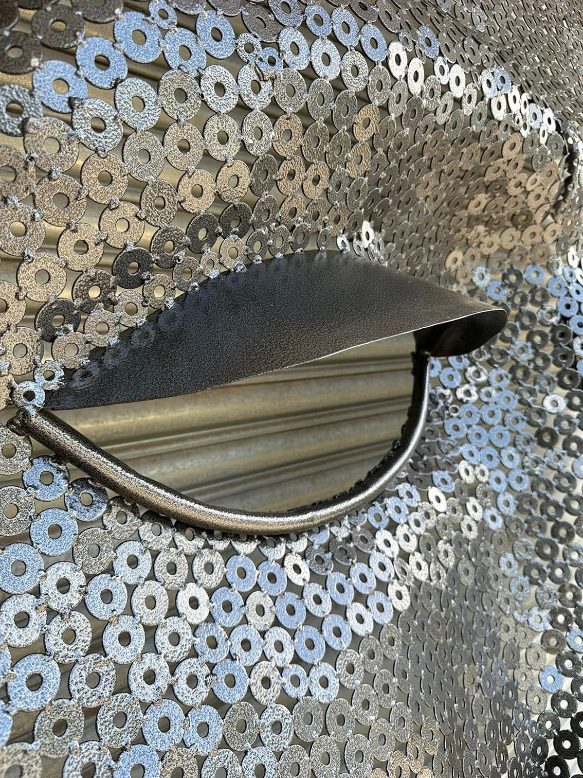 recycled metal washers used to create a large mask sculpture