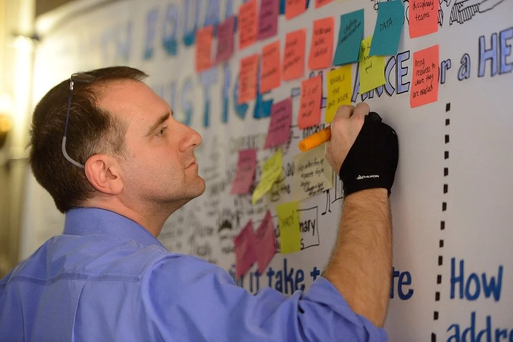 Brian Tarallo records ideas onto a knowledge wall following a World Cafe