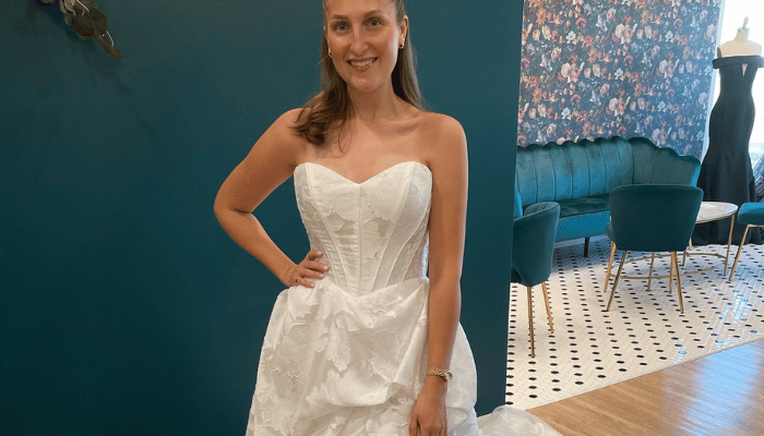 Bride wearing a strapless floral jacquard ball gown wedding dress during a bridal boutique appointment